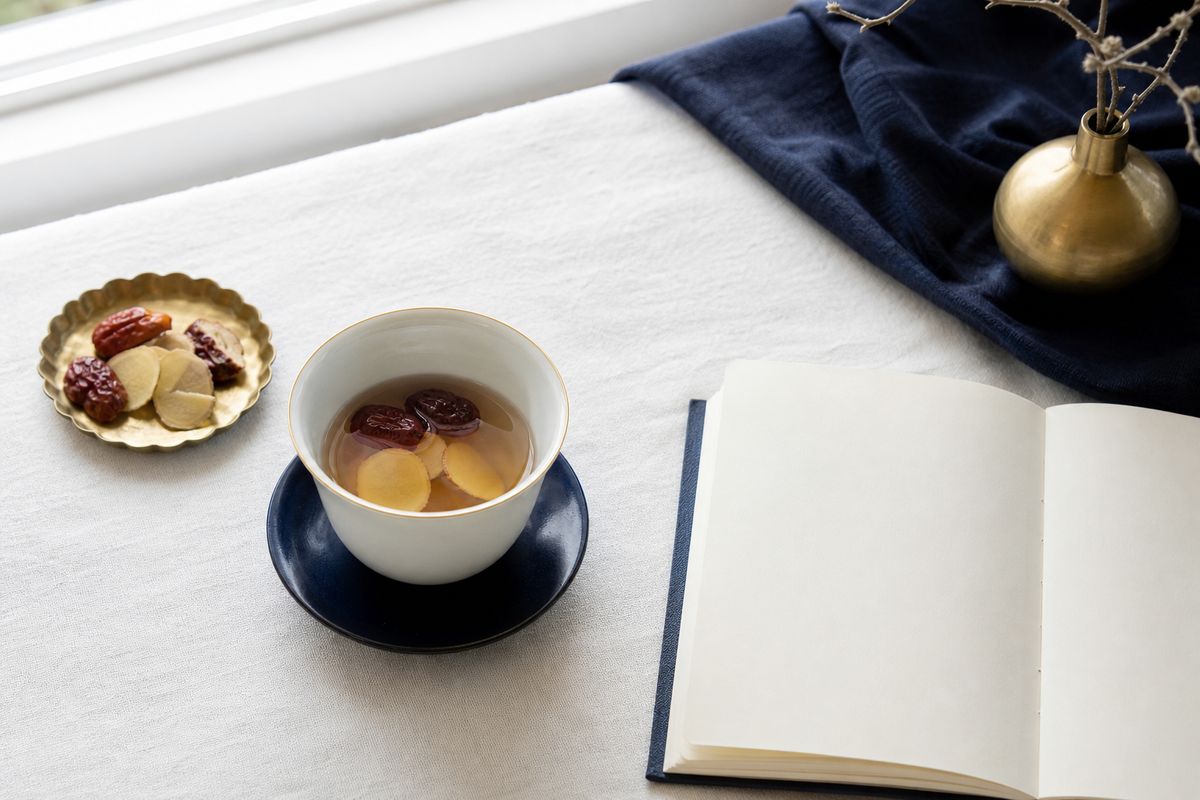 なつめと生姜の温かいお茶と白いノート(イメージ)